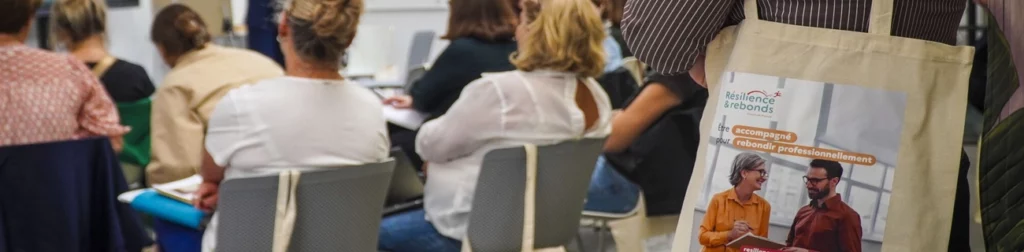Vue sur un tot bag Résilience et Rebonds, avec en arrière plan l'assemblée qui était présente.