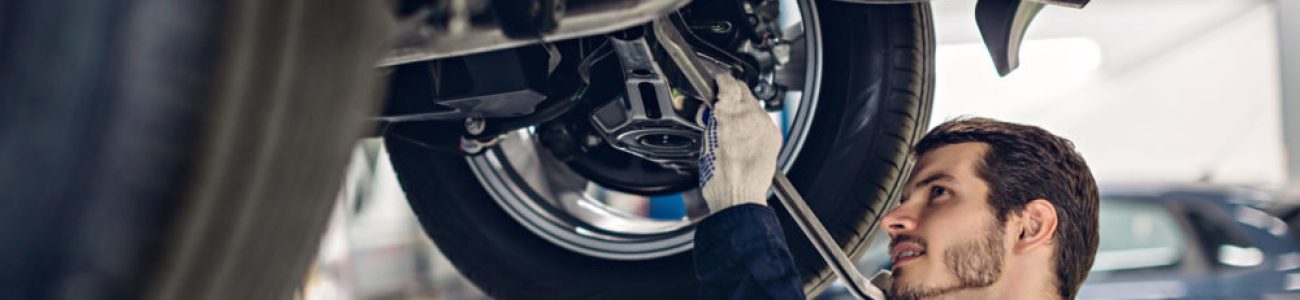 Auto car repair service center. Mechanic examining car suspension